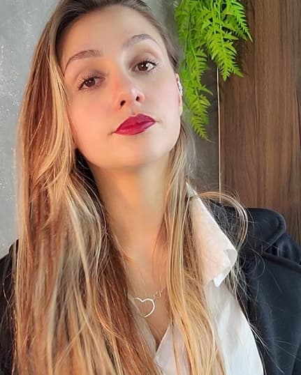 Adriana Leme, de cabelos longos e blazer escuro
