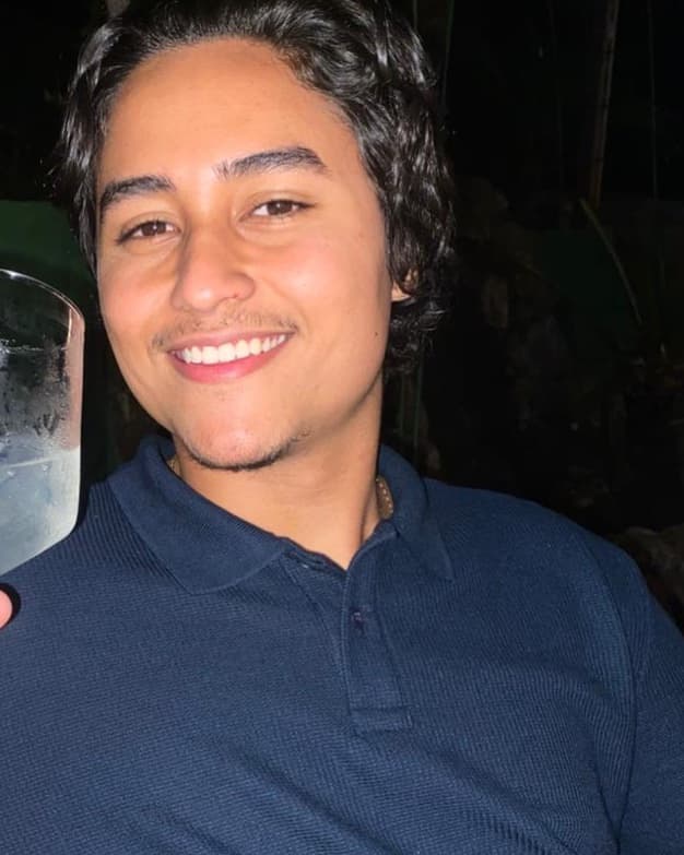 Felipe Andreta sorrindo, de camisa polo azul-marinho