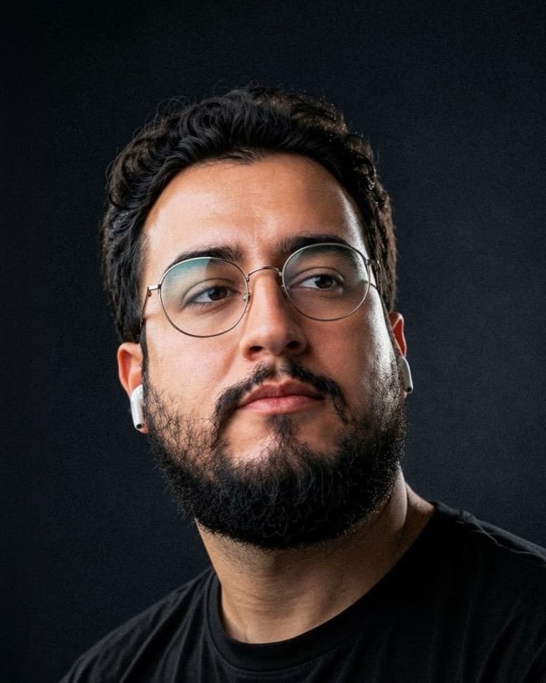 Kaio Caldeira, de óculos e barba, sobre fundo escuro
