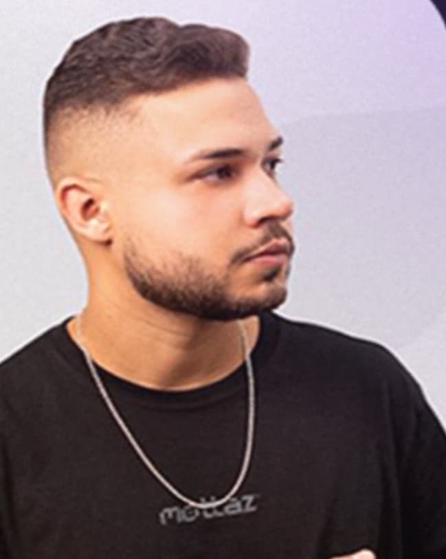 Luan Mota de perfil, com camiseta preta e corrente