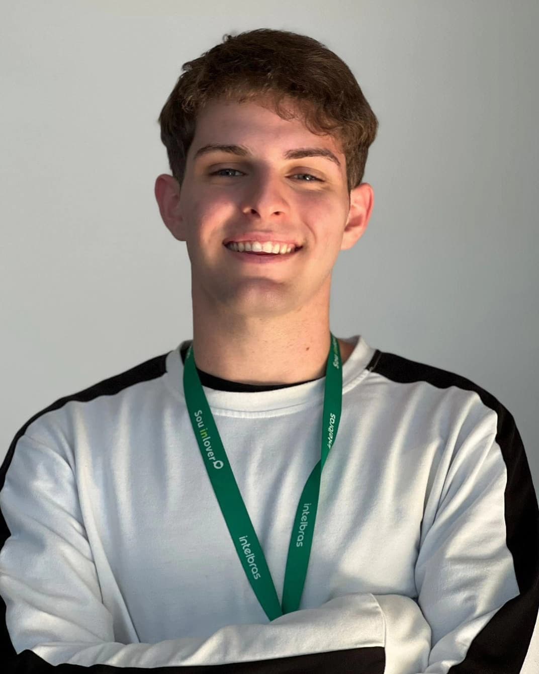 Vitor Spiazi sorrindo, de blusa branca e crachá